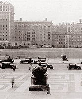 Cars drive along 116th Street with Alma Mater in the foreground 